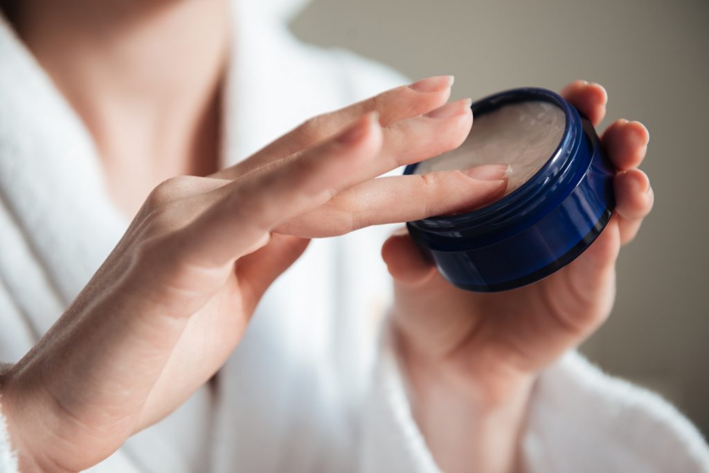 Close up of a young woman hands holding jar of cream