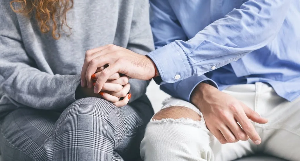Man holding hand of stressed woman